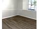 Bright bedroom featuring modern wood-look floors and a window with plantation shutters at 2318 Mohawk Trl, Maitland, FL 32751