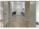Bright hallway featuring tile flooring and white trim, leading to a front door with decorative glass at 2318 Mohawk Trl, Maitland, FL 32751