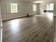 Bright living room with wood-look floors, large windows, and a view into the next room at 2318 Mohawk Trl, Maitland, FL 32751