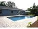 Beautiful swimming pool surrounded by brick pavers and lush tropical landscaping at 2318 Mohawk Trl, Maitland, FL 32751