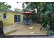Backyard wooden deck featuring a dining set and tropical landscaping at 2810 Nancy St, Orlando, FL 32806