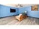 Cozy living room area with blue walls, wood-look flooring, and a ceiling fan at 2810 Nancy St, Orlando, FL 32806