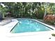 Backyard oasis with a spacious in-ground pool surrounded by lush greenery and patio seating at 2810 Nancy St, Orlando, FL 32806