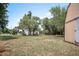 A view of the large backyard with mature trees, green grass, and storage shed at 309 N Kepler Rd, Deland, FL 32724