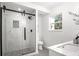 Bright bathroom featuring a glass shower with a sliding door, white tile and light grey flooring at 309 N Kepler Rd, Deland, FL 32724