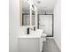 A stylish bathroom shows a double sink vanity with modern faucets and a glass shower with black trim at 309 N Kepler Rd, Deland, FL 32724