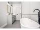 Modern bathroom features a sleek vanity, a bathtub, and a stylish design with white and grey accents at 309 N Kepler Rd, Deland, FL 32724