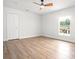 A bright bedroom featuring wood-look flooring, a ceiling fan, and a sunny window at 309 N Kepler Rd, Deland, FL 32724