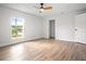 Bright bedroom showcases wood-look flooring, a ceiling fan, and a window providing natural light at 309 N Kepler Rd, Deland, FL 32724