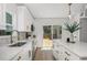 White kitchen featuring stainless steel appliances, island with seating, and luxury vinyl plank flooring at 309 N Kepler Rd, Deland, FL 32724