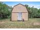 Tan shed with metal door provides secure and dry storage space in the backyard at 309 N Kepler Rd, Deland, FL 32724