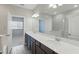 Bathroom with double vanity, a large mirror, and dark cabinetry at 328 Cedar Bark Ln, Sanford, FL 32771