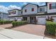 Inviting townhome exterior with a brick paver driveway, trimmed hedges, and attached garage at 328 Cedar Bark Ln, Sanford, FL 32771