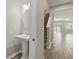 Hallway view with wood-look tile, staircase, half bathroom with pedestal sink, and view to living area at 328 Cedar Bark Ln, Sanford, FL 32771