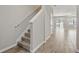Welcoming hallway with wood-look tile floors, a carpeted staircase, and access to the living area at 328 Cedar Bark Ln, Sanford, FL 32771