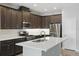 Stylish kitchen featuring stainless steel appliances, dark cabinets, and a central island with a sink at 328 Cedar Bark Ln, Sanford, FL 32771