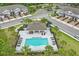 Aerial view of community pool with sun loungers and palm trees in a well-maintained neighborhood at 328 Cedar Bark Ln, Sanford, FL 32771