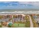Aerial view showing the condo buildings near the beach with a pool and tennis court at 3360 Ocean Shore Blvd # 4050, Ormond Beach, FL 32176