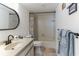 Well-lit bathroom featuring a shower-tub combo, single sink vanity, and decorative mirror at 3360 Ocean Shore Blvd # 4050, Ormond Beach, FL 32176
