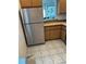 Efficient kitchen area with modern stainless steel refrigerator and natural wood cabinets at 3360 Ocean Shore Blvd # 4050, Ormond Beach, FL 32176