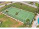 Aerial view of a tennis court surrounded by palm trees and green landscaping at 3360 Ocean Shore Blvd # 4050, Ormond Beach, FL 32176