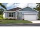 Charming single-story home featuring a two-car garage, stone accents, and neatly landscaped front yard at 3569 Dahlia Dr, Lake Hamilton, FL 33851