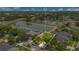 Aerial view showcasing a property bordering a scenic pond and surrounded by lush greenery and neighborhood homes at 4047 Lillian Hall Ln, Orlando, FL 32812