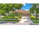 Charming single-Gathering home featuring a well-manicured lawn, mature trees, and a paved driveway at 4047 Lillian Hall Ln, Orlando, FL 32812