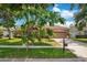 Inviting single-story home featuring a well-kept lawn, lush landscaping, and a convenient two-car garage at 4047 Lillian Hall Ln, Orlando, FL 32812