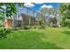 Expansive backyard features lush lawn, landscaping, and screened-in porch for outdoor enjoyment at 4052 Gilder Rose Pl, Winter Park, FL 32792
