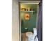 Cozy bathroom features a toilet, decorative shelf with jars, and a Kilauea Lighthouse art print at 4052 Gilder Rose Pl, Winter Park, FL 32792