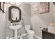Stylish half-bathroom featuring a pedestal sink, decorative mirror and grey walls at 4052 Gilder Rose Pl, Winter Park, FL 32792