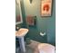 A quaint powder room shows a pedestal sink, toilet, and a Kilauea Lighthouse art print at 4052 Gilder Rose Pl, Winter Park, FL 32792