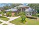 Exterior of a tan home showing the yard with green grass, driveway, and manicured bushes at 4052 Gilder Rose Pl, Winter Park, FL 32792
