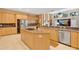 Spacious kitchen featuring an island with a cooktop, stainless steel appliances, and tile flooring at 4052 Gilder Rose Pl, Winter Park, FL 32792