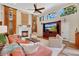 Comfortable living room featuring a fireplace, large windows, and a plush orange sectional sofa at 4052 Gilder Rose Pl, Winter Park, FL 32792