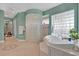 Bright bathroom featuring a glass-blocked shower, soaking tub, and updated finishes at 4052 Gilder Rose Pl, Winter Park, FL 32792
