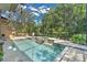 Inviting screened-in pool with a spa, waterfall feature, and lush landscaping for a relaxing outdoor experience at 4052 Gilder Rose Pl, Winter Park, FL 32792