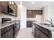 Well-equipped kitchen featuring stainless-steel appliances, granite countertops, and dark wood cabinets at 4125 Lavender Ct, Lake Hamilton, FL 33851