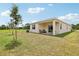 Spacious backyard with covered patio, Adirondack chairs, and expansive green lawn at 4140 Lavender Ct, Lake Hamilton, FL 33851