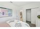 Bright bedroom featuring abstract art, closet, en suite bathroom, and striped bedding at 4140 Lavender Ct, Lake Hamilton, FL 33851