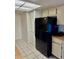 Kitchen with tile flooring, black refrigerator, and white cabinets at 5269 Vineland Rd # 101, Orlando, FL 32811