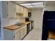The kitchen features white cabinets and black appliances at 5269 Vineland Rd # 101, Orlando, FL 32811