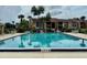 Community swimming pool with lounge chairs, lush landscaping, and plenty of sunshine at 5269 Vineland Rd # 101, Orlando, FL 32811