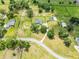 Sprawling aerial view of property with mature trees, fenced pastures, and long driveway at 5478 Nw 153Rd Ct, Morriston, FL 32668