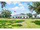 Charming single-story home features a well-maintained lawn, crisp white facade, red door, and lovely shuttered windows at 5478 Nw 153Rd Ct, Morriston, FL 32668