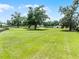 Expansive green grass surrounding a beautiful home, multiple outbuildings, mature trees and black fencing at 5478 Nw 153Rd Ct, Morriston, FL 32668