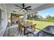 Covered patio featuring an outdoor dining area, ceiling fan and a view of the property's expansive green space at 5478 Nw 153Rd Ct, Morriston, FL 32668