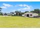 A spacious green field showcases a barn and home on the property, all enclosed by black fencing at 5478 Nw 153Rd Ct, Morriston, FL 32668