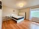 Cozy bedroom with light walls, wood floors, and a large window providing natural light at 6047 Shore Line Dr, Orlando, FL 32819